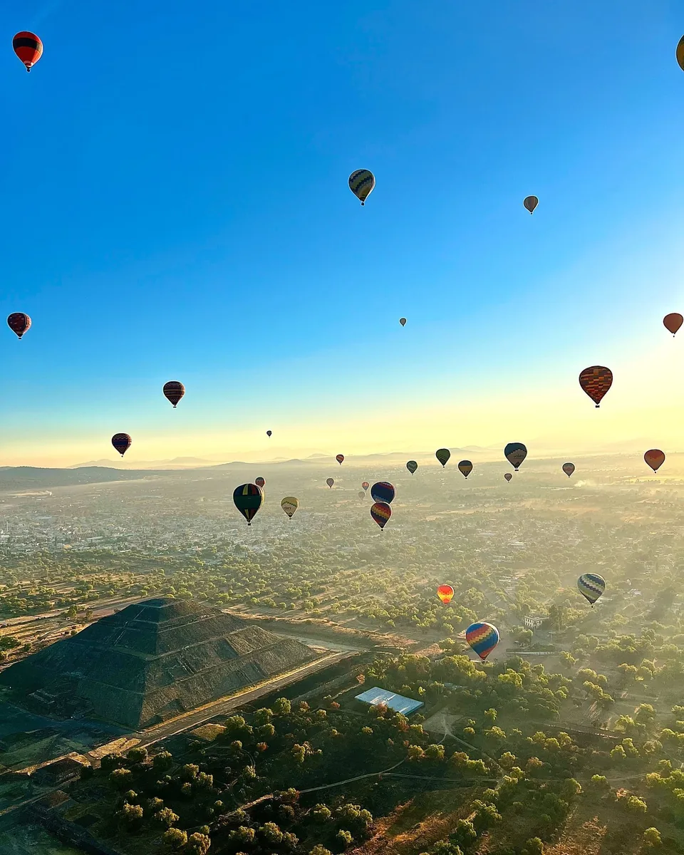 Hot air balloons over the Teotihuacan valley under a completely clear blue sky