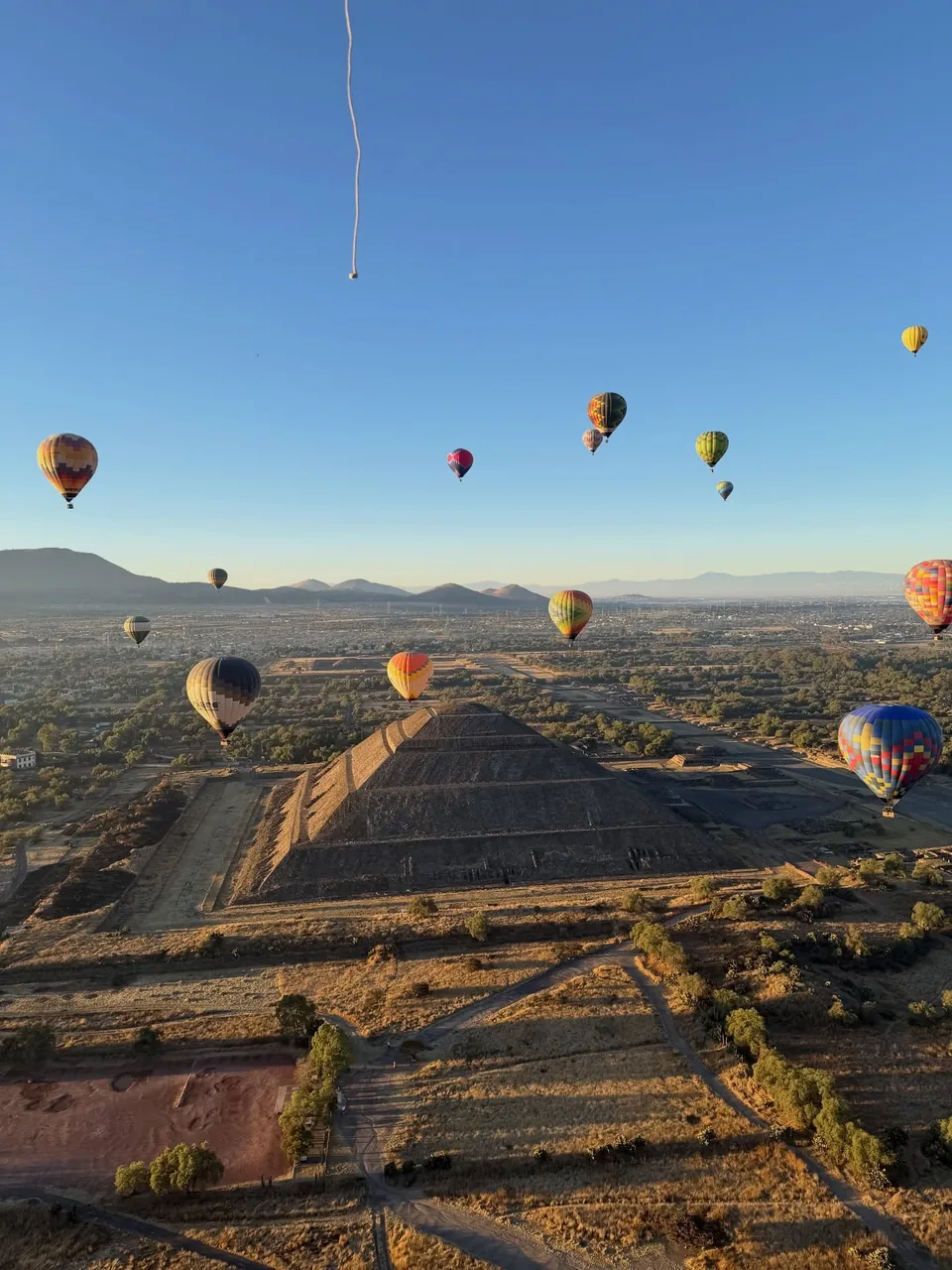 Hot air balloons over the Pyramid of the Sun on a clear morning at Teotihuacan
