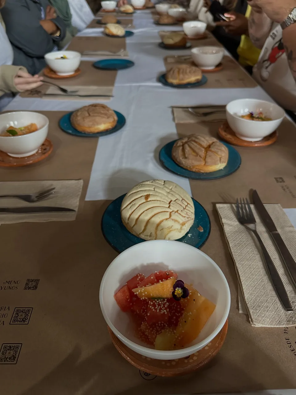 A long breakfast table set with pan dulce and fruit at La Gruta Teotihuacan