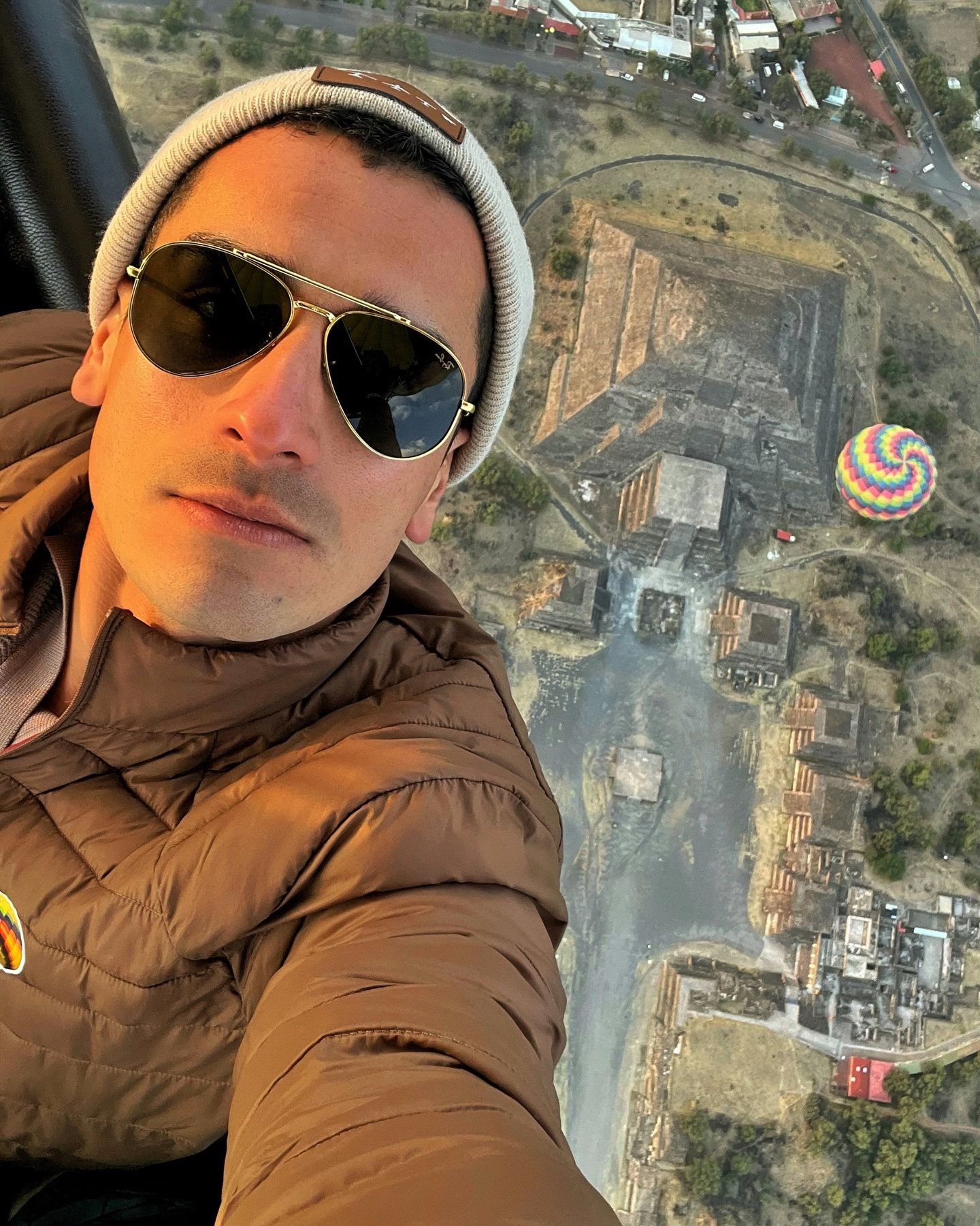 A passenger takes a selfie with the Teotihuacan ruins directly below the basket
