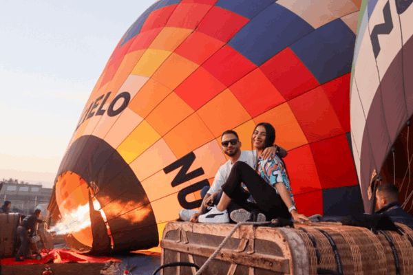 Couple enjoying a romantic sunrise hot air balloon flight over Teotihuacan after booking online